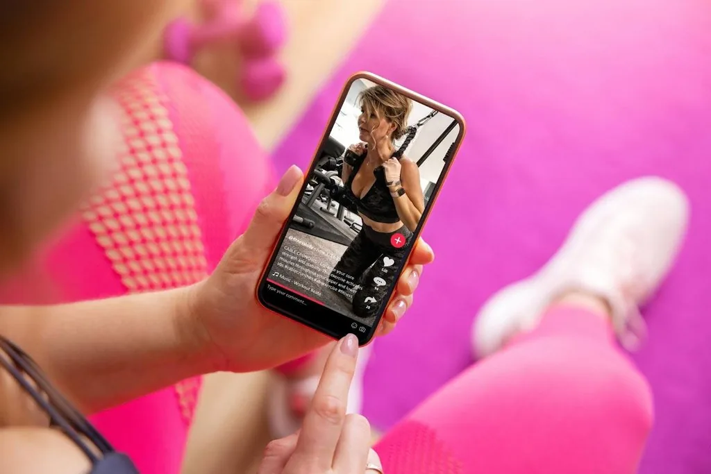 a woman checking fitness tiktok videos