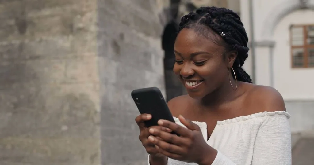 a young girl using her phone on the street 
