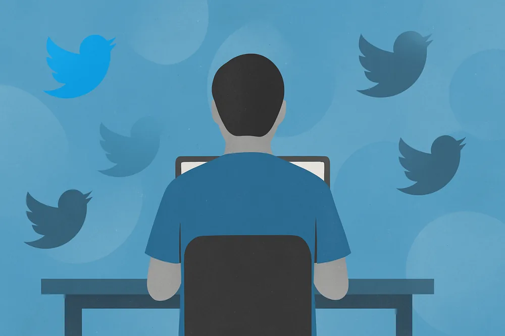 Person viewed from behind at a laptop, with fading Twitter icons floating around them.